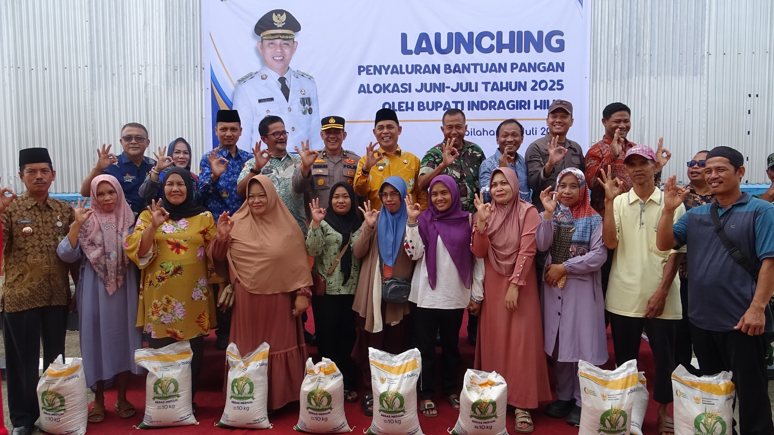 Bupati Indragiri Hilir Herman dan  forkopimda foto bersama masyarakat penerima bantuan beras di Kecamatan Tembilahan Hulu, Kamis (17/7/2025).