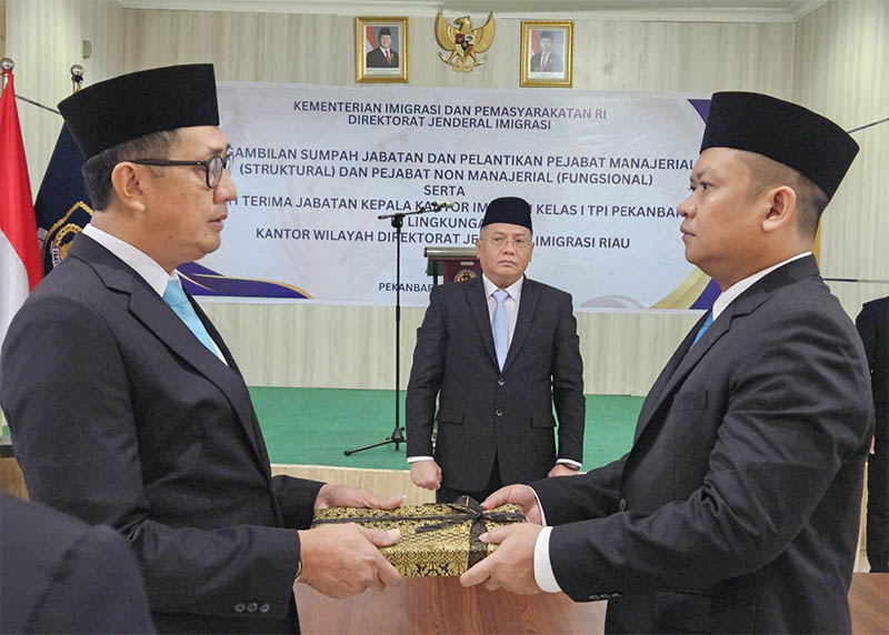 Plt Kepala Kantor Imigrasi Alimuddin (kiri) melakukan serah terima jabatan kepada pejabat definitif Ryang Yang Satiawan, disaksikan Kepala Kanwil Ditjenim Riau Agung Prianto, Rabu (16/7/2025).