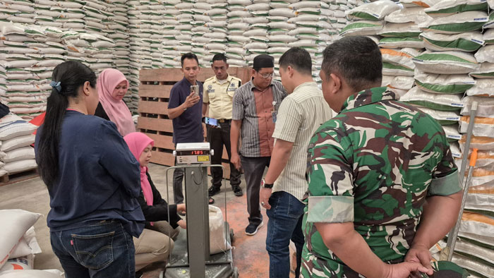 Petugas dari DKP Bengkalis bersama Kodim 0303/Bengkalis dan Bulog melakukan pemeriksaan kualitas beras bantuan pangan di Gudang Bulog Damon sebelum disalurkan kepada KPM, Jumat (18/7/2025).