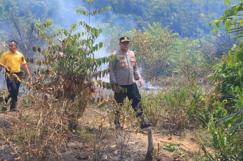 Kapolres Kampar AKBP Boby Putra Ramadhan S bersama satgas gabungan langsung turun langsung memadamkan lahan yang terbakar di perbatasan Kabupaten Kampar, Riau, dan
