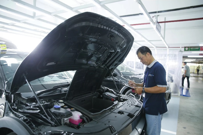 Teknisi melakukan pengecekan mobil bekas.