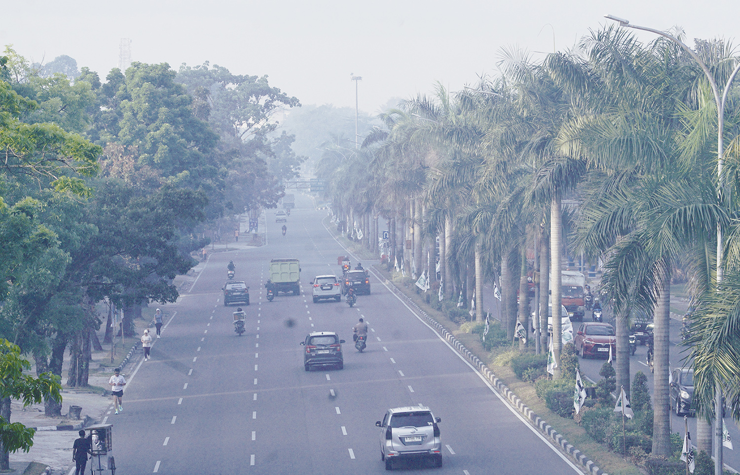 ASAP:  Kabut asap tipis dampak kebakaran hutan dan lahan menyelimuti kawasan Jalan Jenderal Sudirman Pekanbaru, Ahad (20/7/2025).