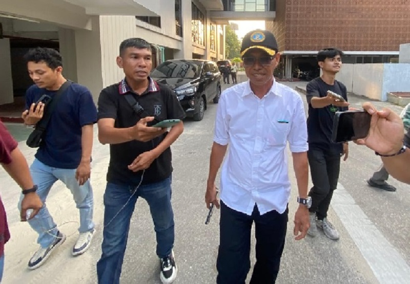 Mantan Bupati Rohil Afrizal Sintong berjalan keluar gedung Kejati Riau usia menjalani pemeriksaan, Senin (21/7/2025).