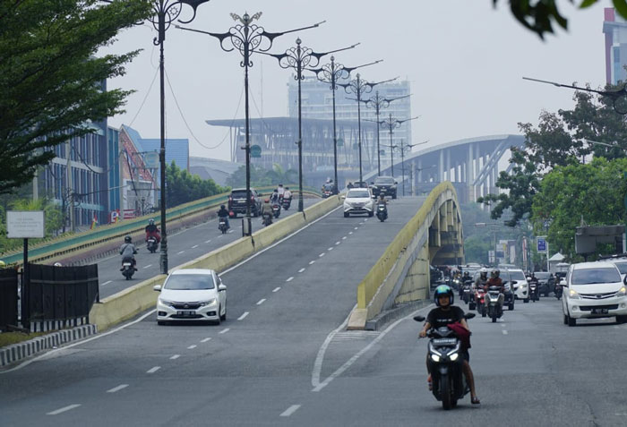 Kabut asap  mulai selimuti Kota Pekanbaru ketika pengendara melintas di Jalan Jenderal Sudirman, Pekanbaru, Selasa (22/7/2025).