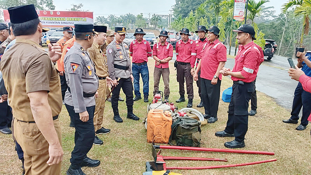 Tim Fire Emergency Response Team PT RAPP memberikan penjelasan terkait peralatan penanggulangan karhutla kepada Kapolres Kuansing dan Pj Sekda di lapangan Mapolres Kuansing, Selasa (22/7/2025).