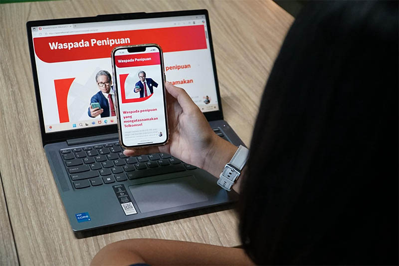 Pelanggan Telkomsel membaca informasi terkait imbauan hati-hati terhadap penipuan digital, Kamis (24/7/2025).