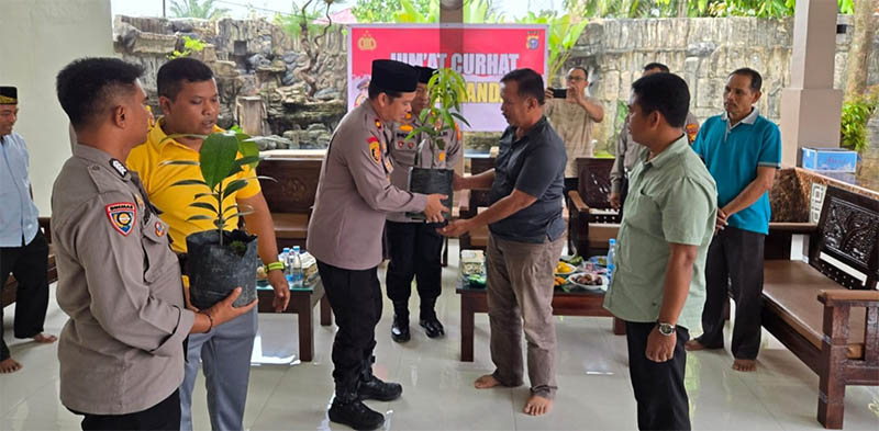 Kapolsek Kompol Primadona Caniago menyerahkan bibit pohon kepada Ketua RW 20 Mukhlis di Kelurahan Air Jamban, Kecamatan Mandau.
