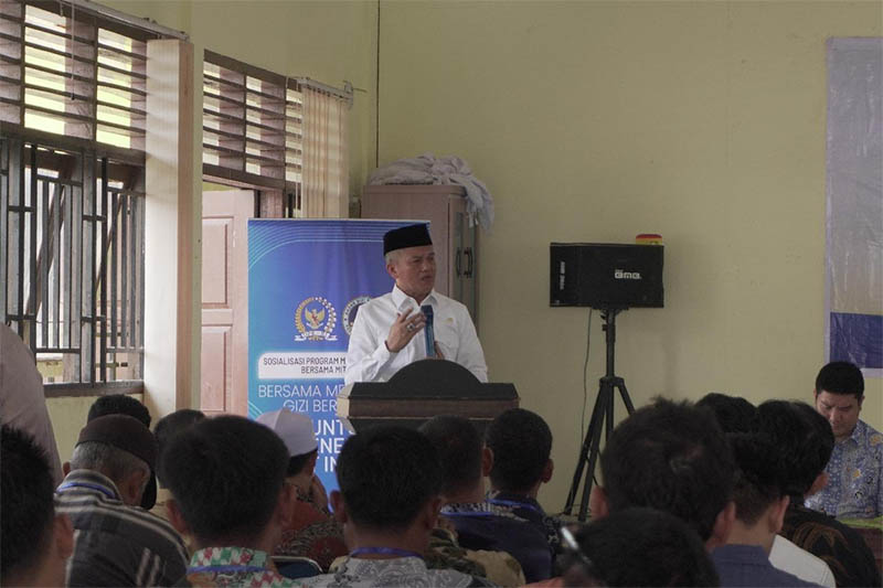 Anggota Komisi IX DPR RI Sahidin memberi penjelasan saat sosialisasi program MBG di Aula Desa Petapahan, Tapung, Selasa (22/7/2025).