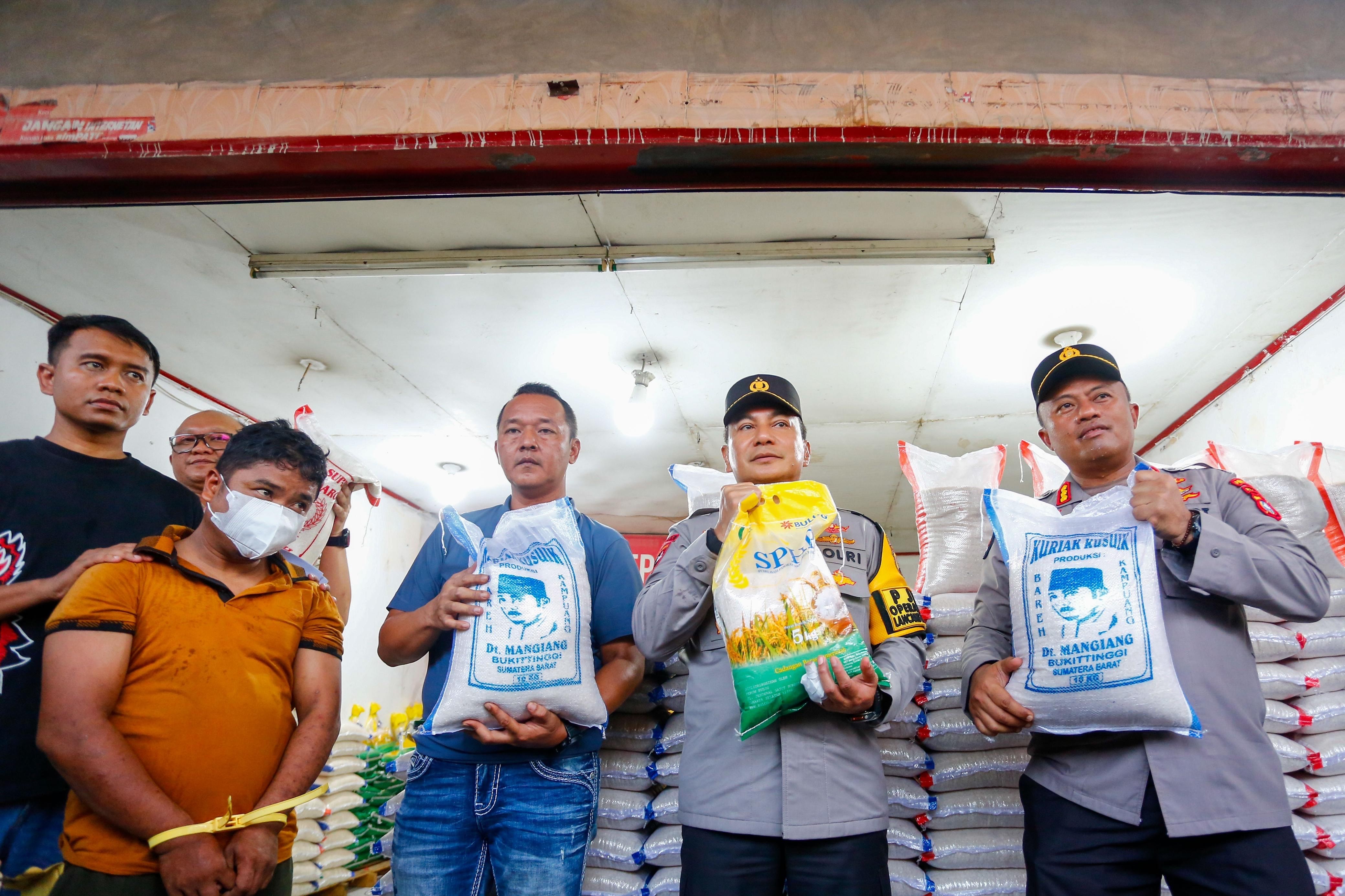 Kapolda Riau Irjen Pol Herry Heryawan  bersama Kabid Humas Polda Riau Kombes Pol Anom Karibianto, dan Dirkrimsus Kombes Pol Ade Kuncoro menunjukan kemasan beras premium yang sudah dicampur beras Bulog
