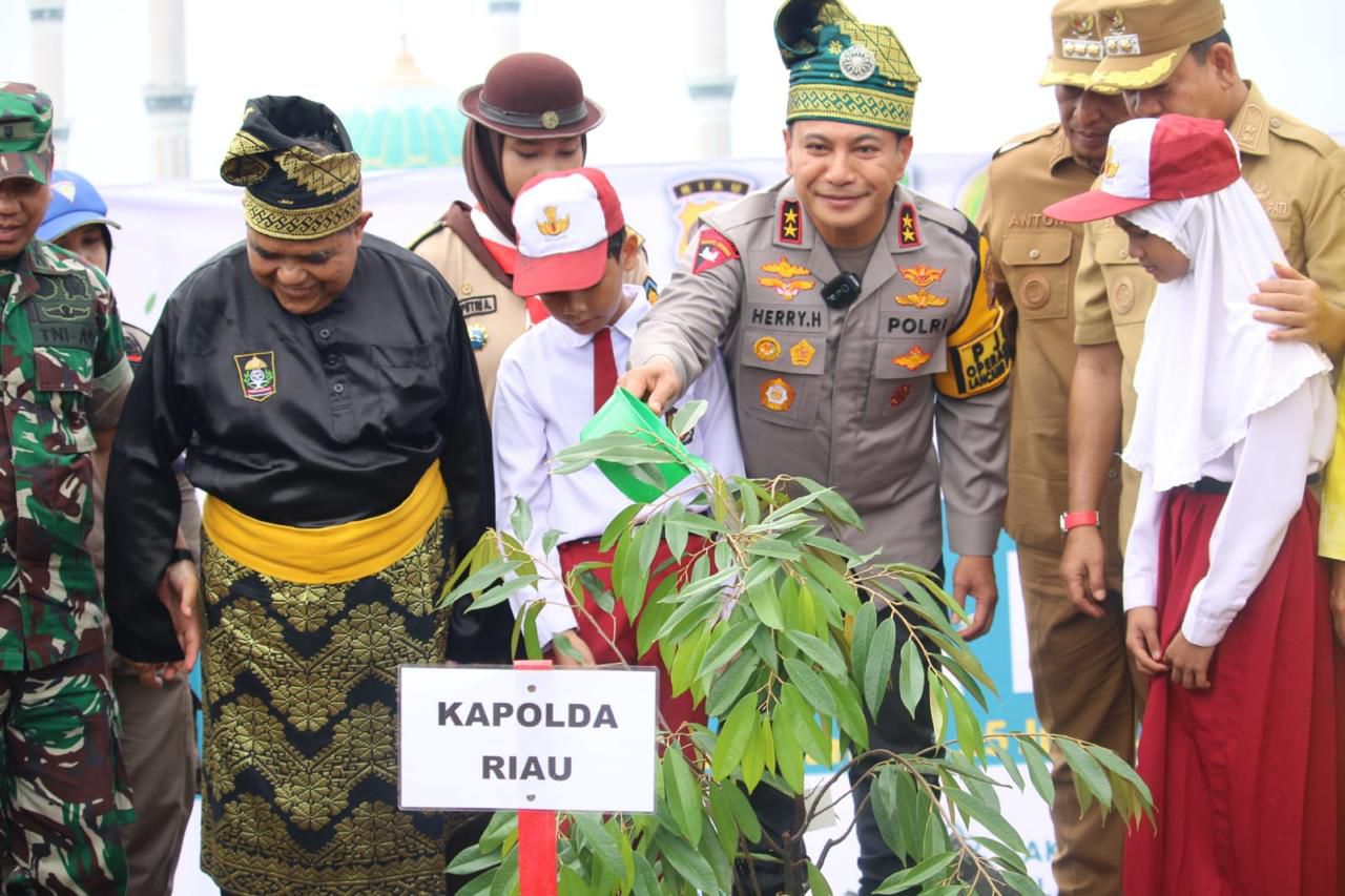 Kapolda Riau Irjen Pol Herry Heryawan menyiram pohon yang ditanam saat kunjungan kerja ke Rokan Hulu, Jumat (25/7/2025)