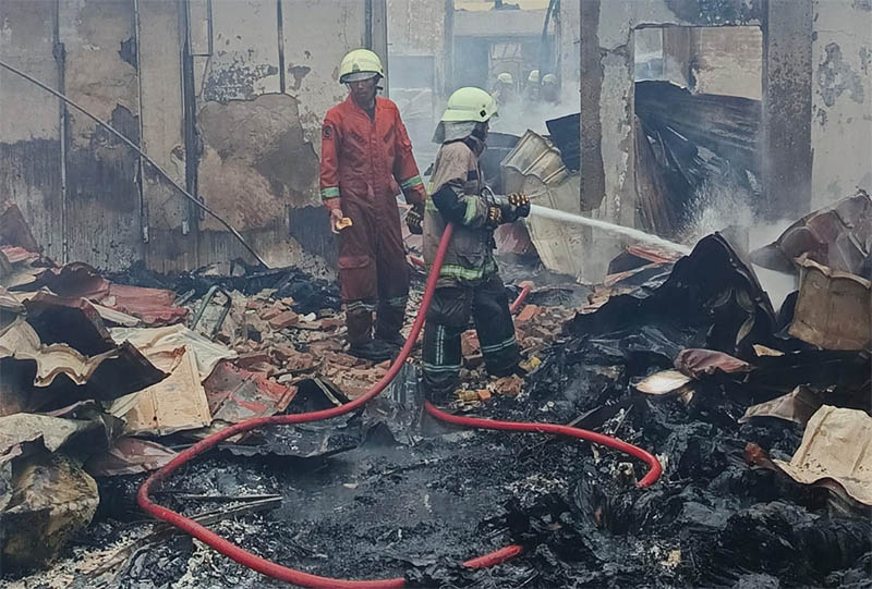 Petugas damkar saat melakukan proses pemadaman dan pendinginan di kantor Disnakertrans Riau yang terbakar pada Senin (28/7/2025) dini hari.