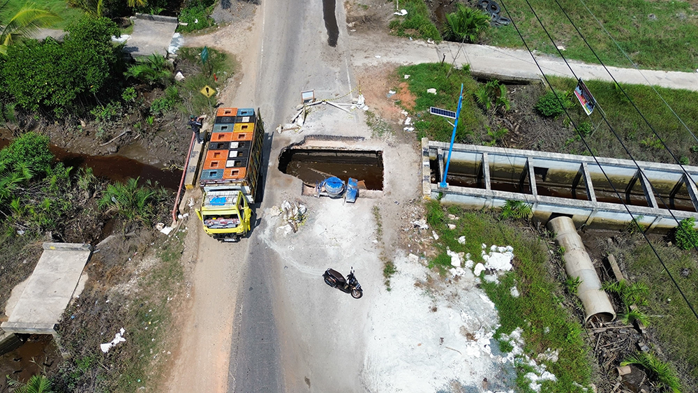 Lubang menganga di Jalan Lintas Dumai-Sungai Pakning tepatnya di Dusun Parit Rodi, Desa Bukitbatu Kecamatan Bukitbatu belum diperbaiki, Ahad (27/7/2025).