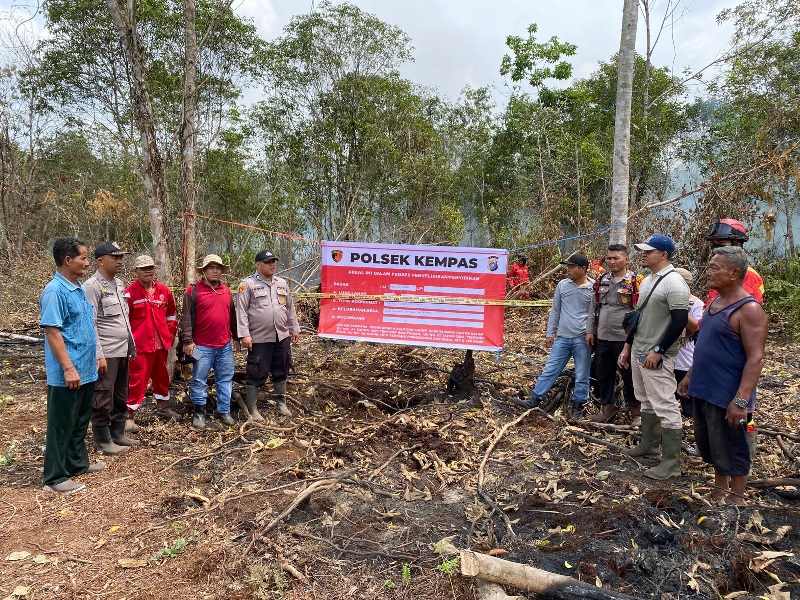 Petugas kepolisian memasang garis polisi di lokasi awal penyebab karhutla di Dusun Teluk Bagus, Desa Bayas Jaya, Kecamatan Kempas, Kabupaten Inhil, Ahad (27/7/2025).