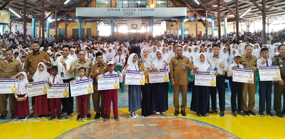 Sekda Rohil H Fauzi Efrizal, anggota DPR RI Dr Hj Karmila Sari foto bersama sejumlah kepala OPD dan siswa setelah penyerahan simbolik beasiswa PIP Fase I/2025 di Perguruan Wahidin, Bagansiapiapi.