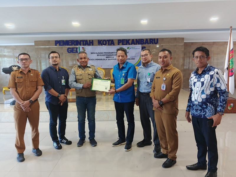 Penyerahan secara simbolis BPJS Ketenagakerjaan kepada pengurus LPS Sehati Kelurahan Sidomulyo Barat, Afriwadi  di MPP Pekanbaru, Selasa (29/7/2025).