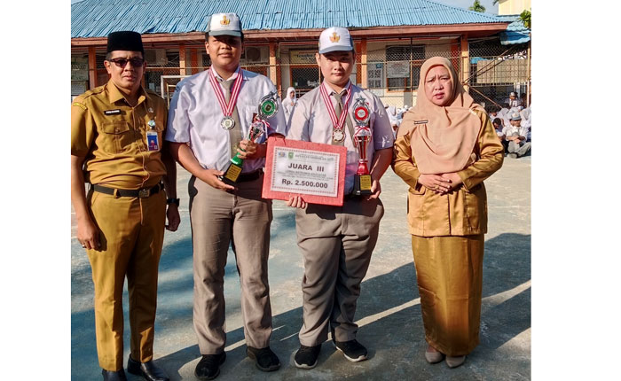 Dua siswa SMKN 1 Tembilahan menerima penghargaan dari sekolah setelah berhasil meraih prestasi FLS3N tingkat SMK se Provinsi Riau, Senin (31/7/2025).