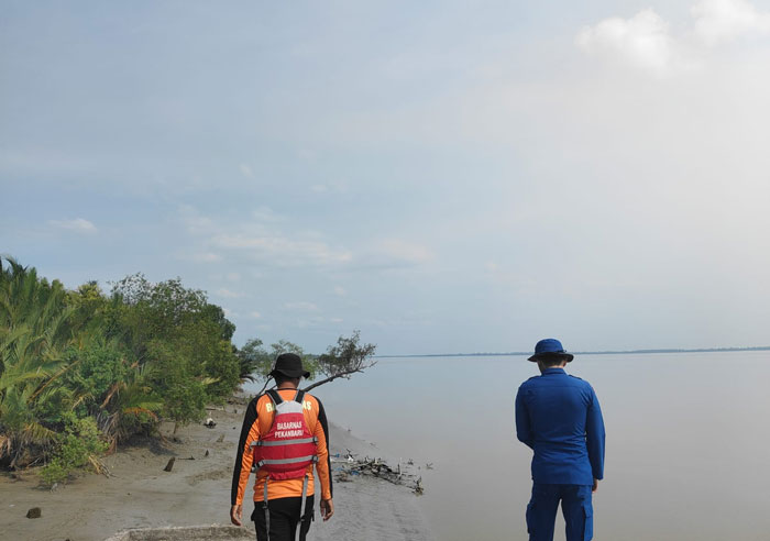 Personil gabungan mengamati tepian Sungai Rokan dalam operasi pencarian korban yang diduga hilang di sungai Rokan, diduga diserang buaya, Kamis (31/7/2025).