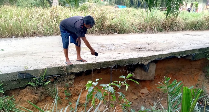 Warga menunjuk kondisi jalan yang rawan ambruk setelah bagian pondasi jalan yang mengelami pengerusan di jalan Astra Kelurahan Bagan Batu Kota, Bagan Sinembah.
