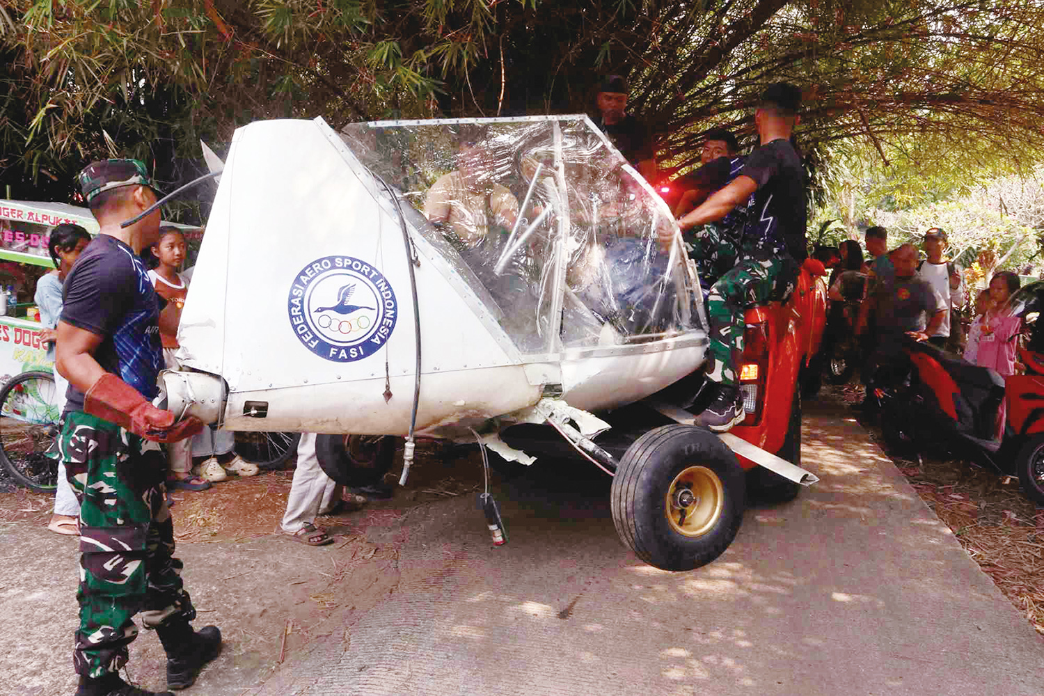Petugas dan Basarnas membawa bagian dari &ldquo;bangkai&rdquo; pesawat latih Microlight Fixedwing Quicksilver GT500 yang mengalami kecelakaan saat terbang di Desa Benteng, Kecamatan Ciampea, Kabupaten Bogor, Ahad (3/8/2025).