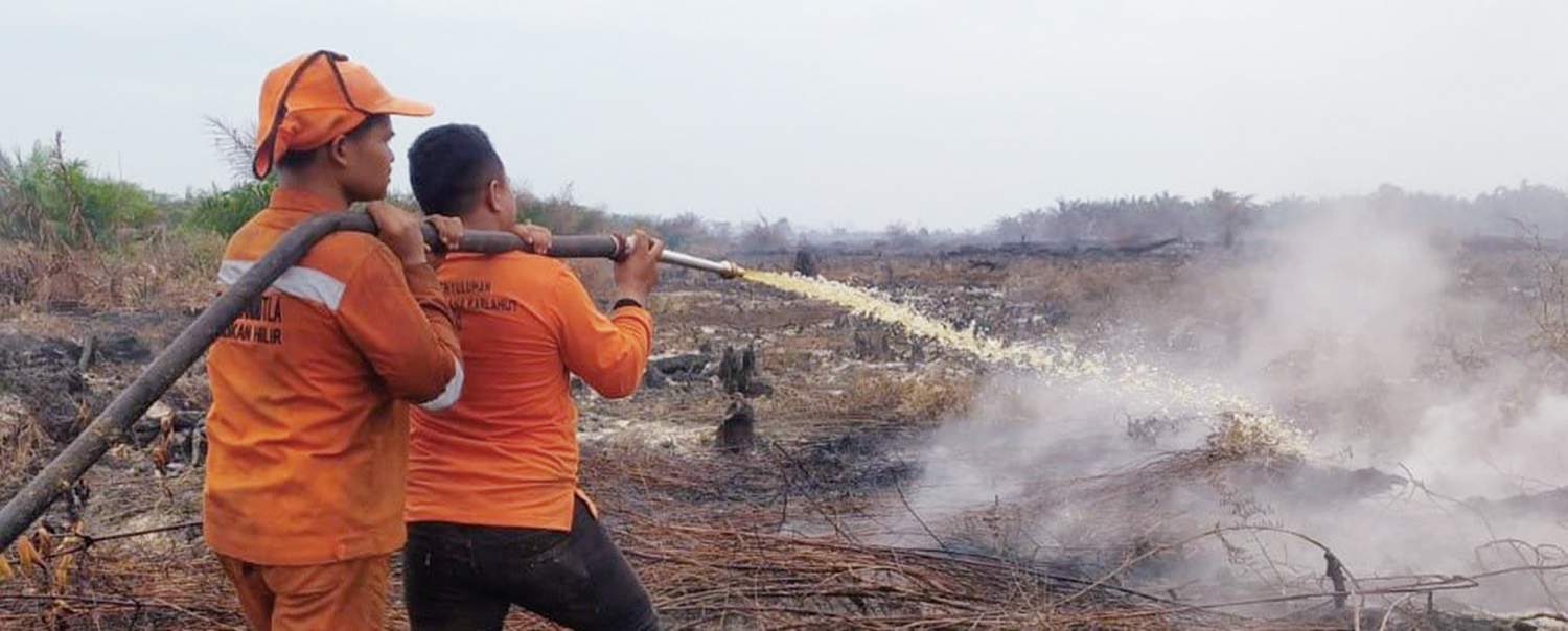 Personel BPBD Rokan Hilir melakukan&nbsp;pendinginan lahan bekas kebakaran yang masih menyisakan asap di Sungai Daun, Kecamatan Pasir Limau Kapas, baru-baru ini.