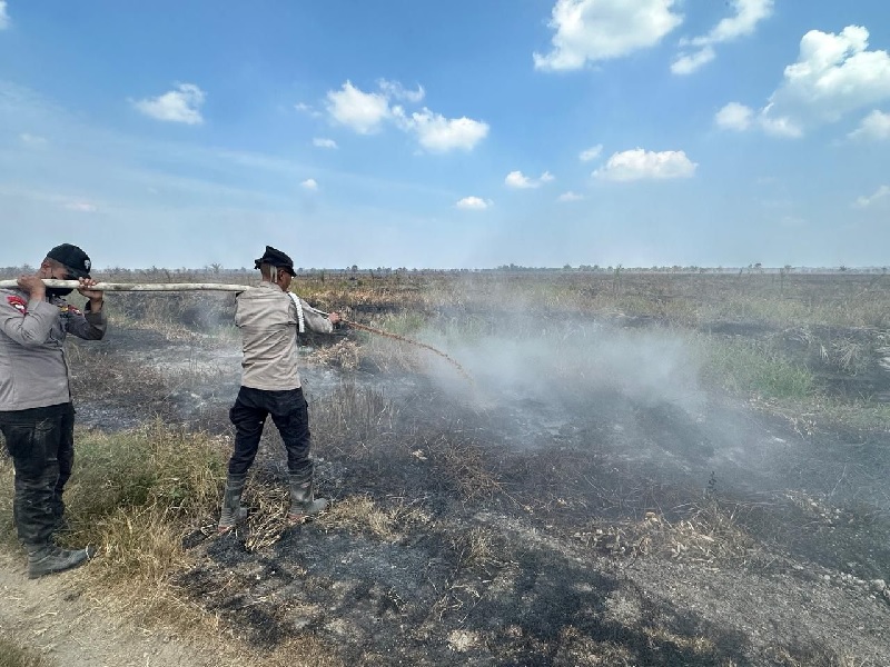Personel Brimobda Riau saat melakukan pendinginan usai melakukan pemadaman Kebakaran hutan dan lahan (karhutla) di Kabupaten Rokan Hilir.
