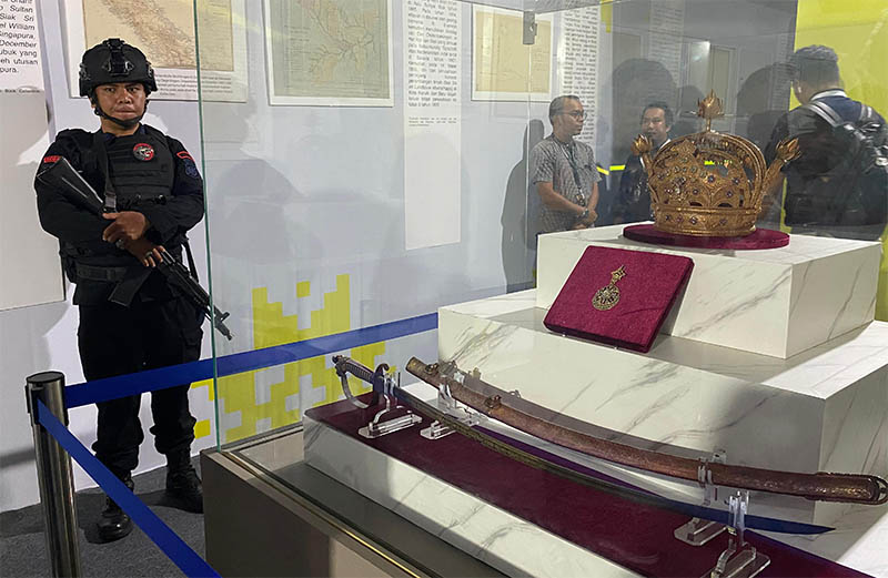 Petugas bersenjata lengkap menjaga mahkota dan pedang Kesultanan Siak yang dipamerkan di Pekanbaru