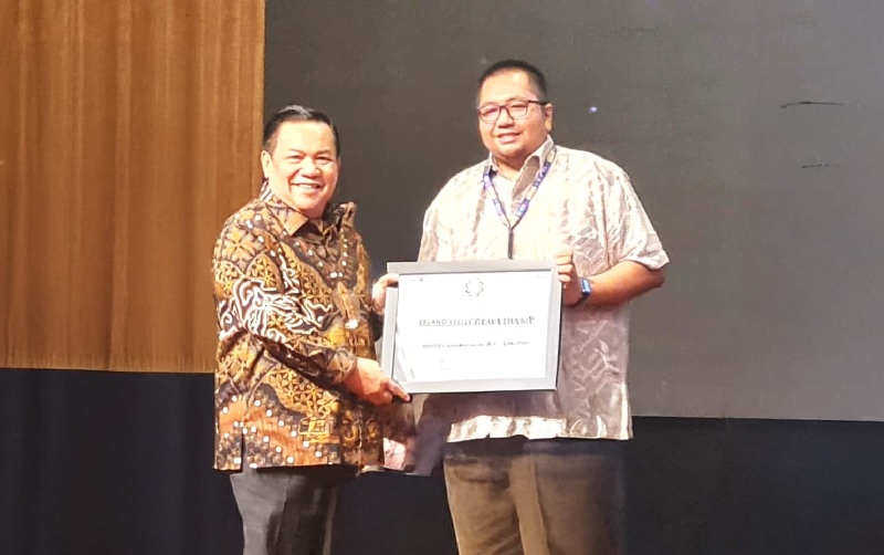 Wagubri SF Hariyanto (kiri) menyerahkan penghargaan Industry Marketing Champion 2025 kategori Multifinance kepada Marketing Manager FIFGROUP Area Riau Daratan, Erland Veda.
