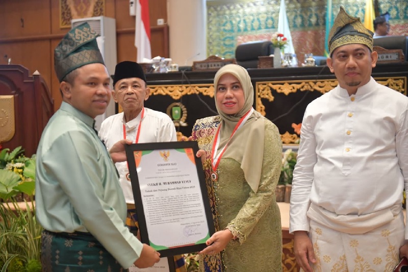 Gubri H Abdul Wahid menyerahkan penghargaan untuk Syekh H Muhammad Yusuf diterima ahli waris Suriyati, sedangkan penghargaan H Arsyad, MS diterima Zulkarnain di Gedung DPRD Riau, Sabtu (9/8/2025).