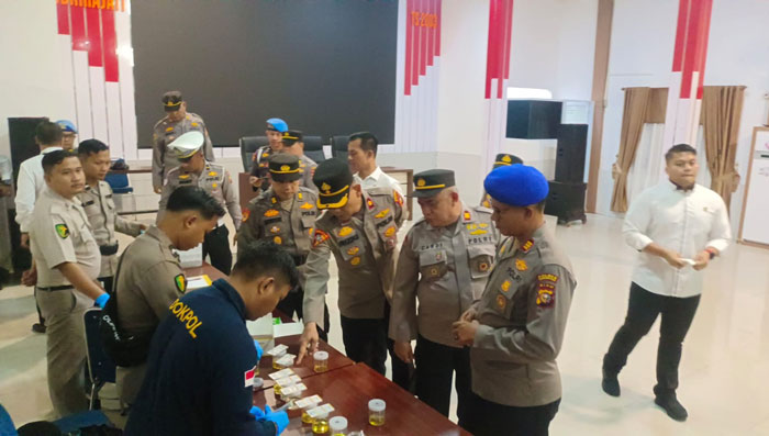 Perwira Polres Inhil menyerahkan hasil urine dalam pemeriksaan oleh Provos Polda Riau dan Tim Laboratorium RS Bhayangkara di Aula Mapolres Inhil, Senin (11/8/2025).