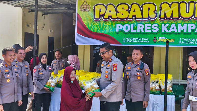Kapolres Kampar AKBP Boby Putra Ramadhan S menyerahkan beras saat pasar murah di halaman Mapolsek Tambang, Selasa (12/8/2025).