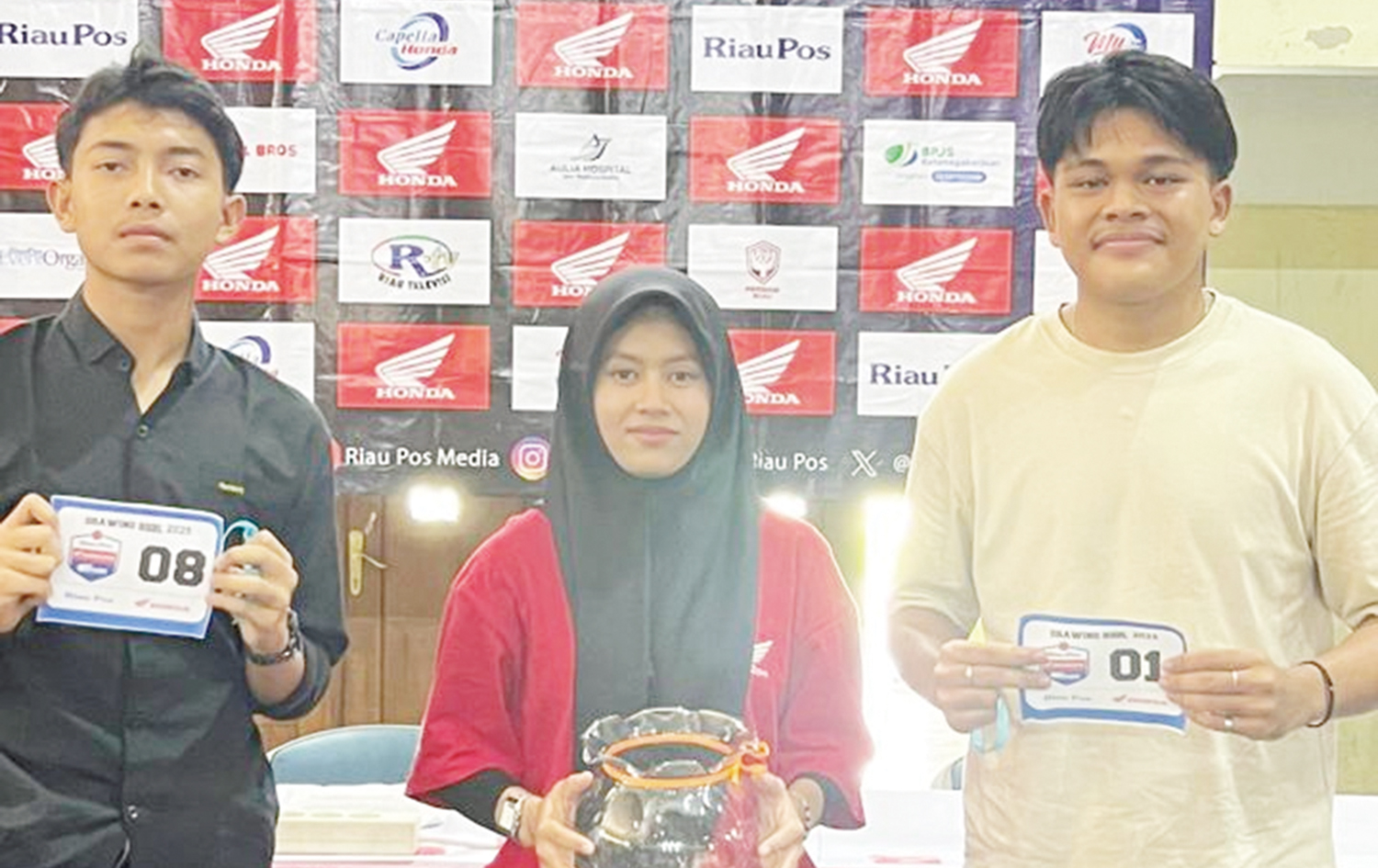 Perwakilan Tim SMAN 1 Tualang (baju krem) memperlihatkan nomor setelah mencabut undian di samping perwakilan Tim SMAN 1 Siak (baju hitam) di GOR Tualang, Selasa (12/8/2025).