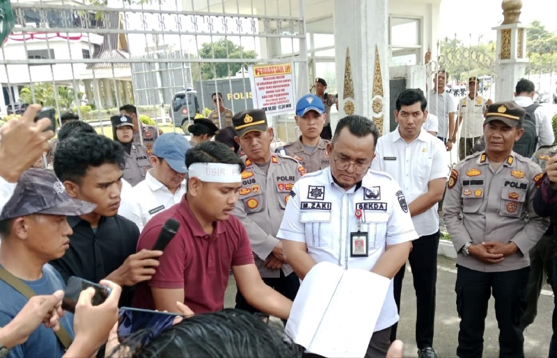 Koordinator Aksi Damai Warga Desa Bangun Jaya Kecamatan Tambusai Utara menyampaikan pernyataan sikap di hadapan Sekda Rohul Muhammad Zaki SSTP MSi di depan pintu gerbang kantor Bupati Rohul.