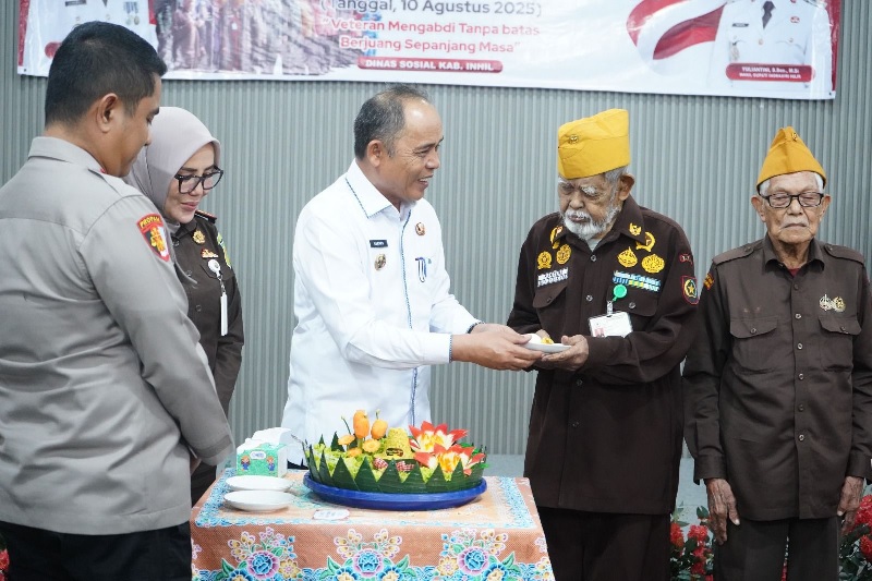 Bupati Inhil Herman menyerahkan tumpeng ke perwakilan veteran dalam memperingati hari veteran nasional disalah satu hotel di Tembilahan, Rabu (13/8/2025).