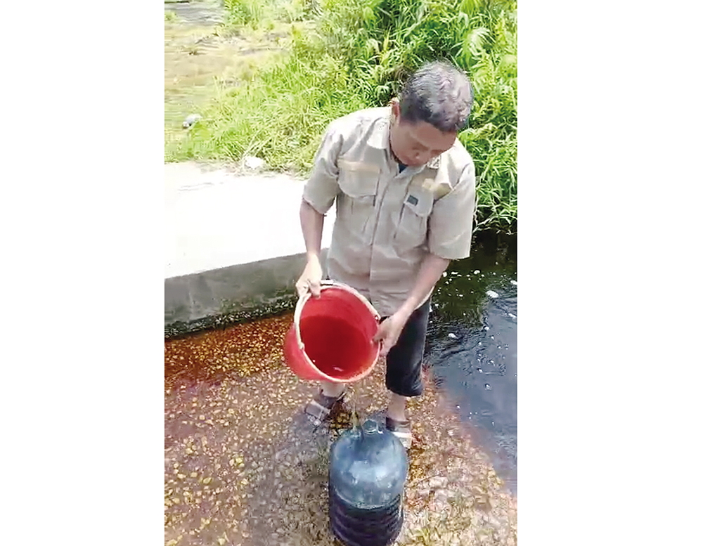 Warga pelanggan PDAM Tirta Terubuk terpaksa mengambil air parit untuk keperluan mandi dan mencuci, Rabu (13/8/2025).