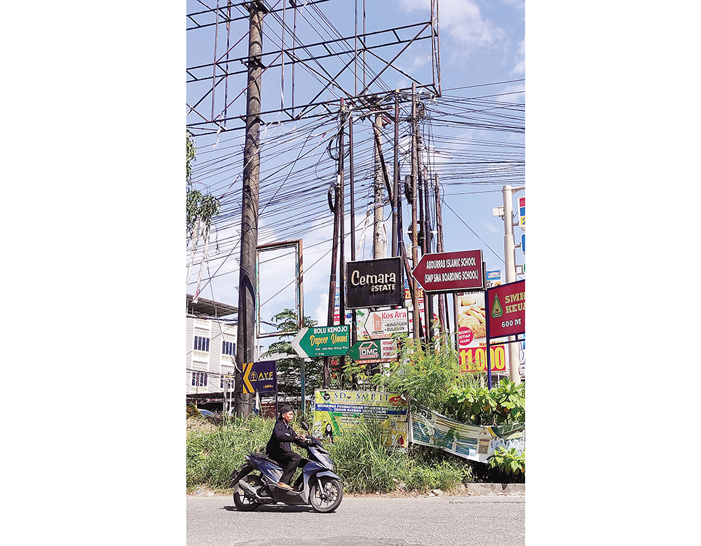 Tiang dari berbagai provider internet kabel optik menumpuk di persimpangan Jalan Bakti - Soekarno Hatta, Pekanbaru, Rabu (6/8/2025) ft: MHD AKHWAN/RIAUPOS