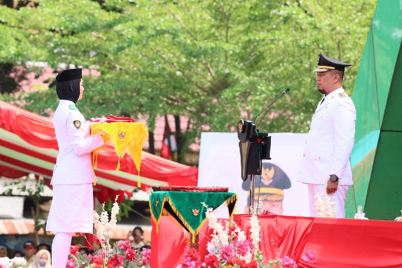 Bupati Inhu, Ade Agus Hartanto usai menyerahkan bendera merah putih kepada pembawa baki, Haura Gania Rahma dari SMAN 1 Lirik, Ahad (17/8/2025)