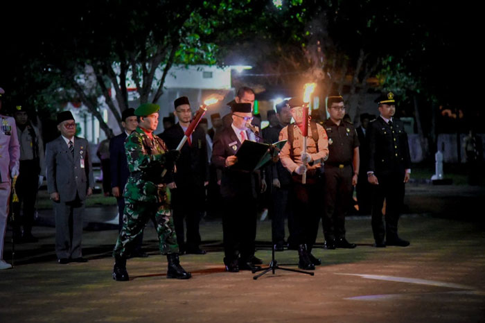 Wabup Bengkalis Bagus Santoso membacakan naskah ikrar pada malam renungan suci di TMP Kesuma Kesatria Bengkalis, Ahad (17/08/2025) pukul 00.00 WIB.