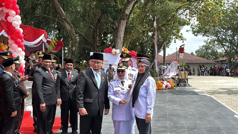 Wakil Bupati Kampar Misharti didampingi Kalapas Alexander Lisman Putra menyerahkan remisi kepada warga binaan di Lapangan Pelajar Bangkinang Kota, Ahad (17/8/2025).