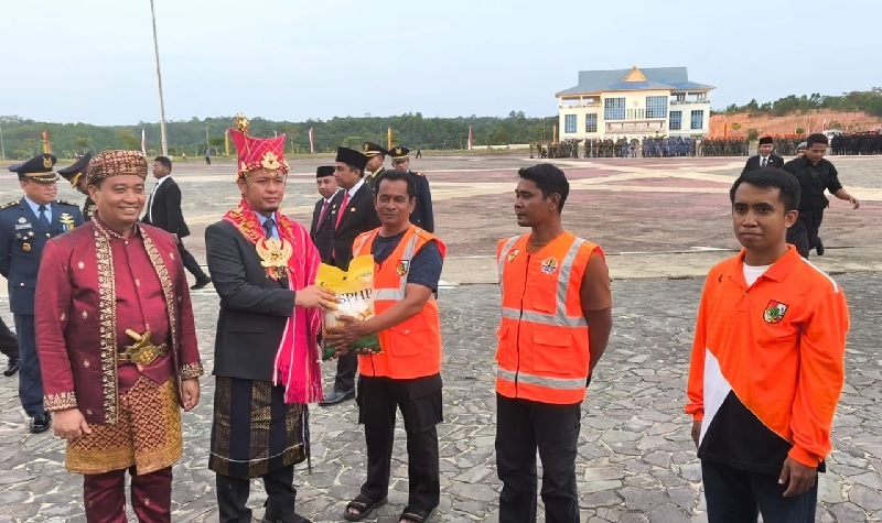 Wako Pekanbaru Agung Nugroho didampingi Wawako Pekanbaru Markarius Anwar memberikan bantuan sembako pada petugas kebersihan di sela-sela upacara penurunan bendera Merah Putih HUT ke 80 RI, Ahad
