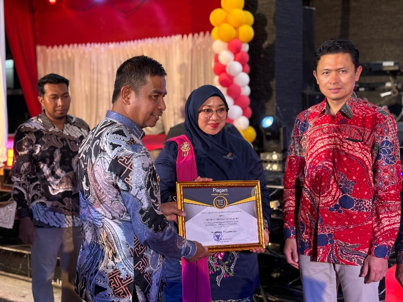Bupati Kampar Ahmad Yuzar SSos MT menyerahkan piagam penghargaan Program CSR kepada Analis Dept FORKOM Vallerina didampingi Area Manager KKKS EMP Bentu Yoyok S Purwanto, Ahad (17/8/2025) malam.