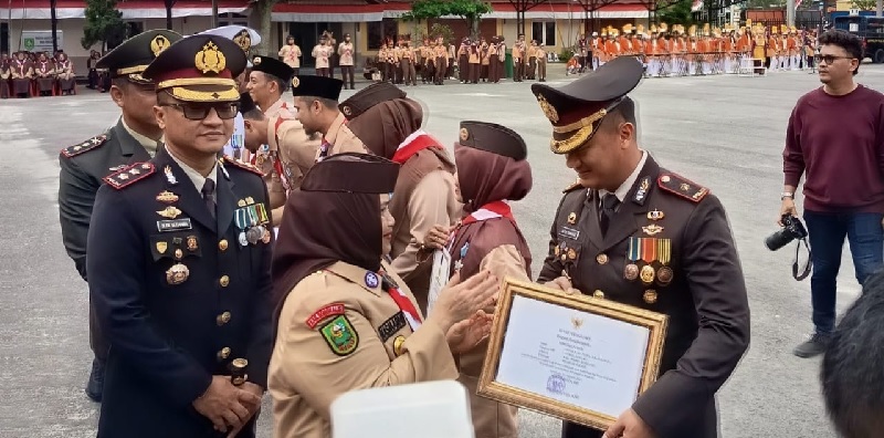 Bupati Bengkalis Kasmarni menyerahkan penghargaan kepada Kapolres Bengkalis AKBP Budi Setiawan di halaman Kantor Camat Mandau, Selasa (19/8/2025).