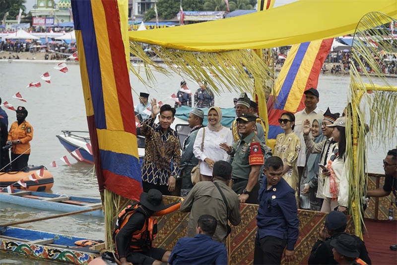 Wapres Gibran dan istri Selvi Ananda Putri bersama rombongan melambai-lambaikan tangan pada penonton pacu jalur di Tepian Narosa Teluk Kuantan