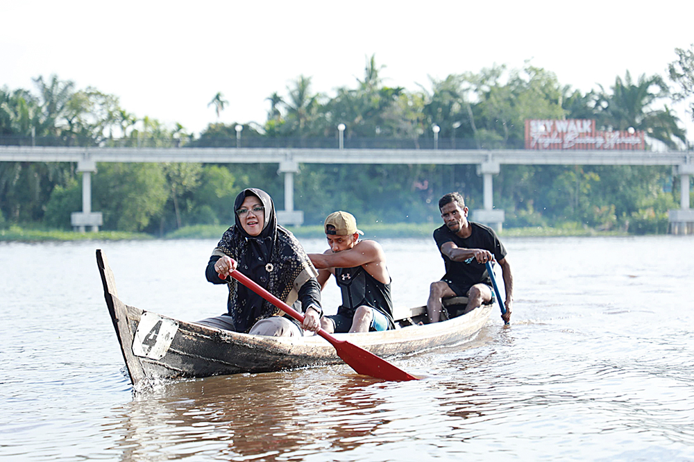 Bupati Siak Afni mendayung perahu saat penutupan iven Lomba Dayung Sampan Tradisional di tepian Sungai Jantan, Kelurahan Kampung Dalam, Kecamatan Siak, Senin (18/8/2025).