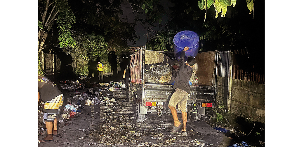 Petugas DLHK Pekanbaru mengangkut sampah yang berserakan di badan Jalan Kutilang Sakti, Kecamatan Binawidya, Senin (18/8/2025) malam.