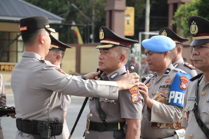 Kapolres Inhu AKBP Fahrian Saleh Siregar SIK MSI memasangkan tanda pangkat kepada salah seorang Kapolsek pada acara Sertijab, Senin (25/8/2025)