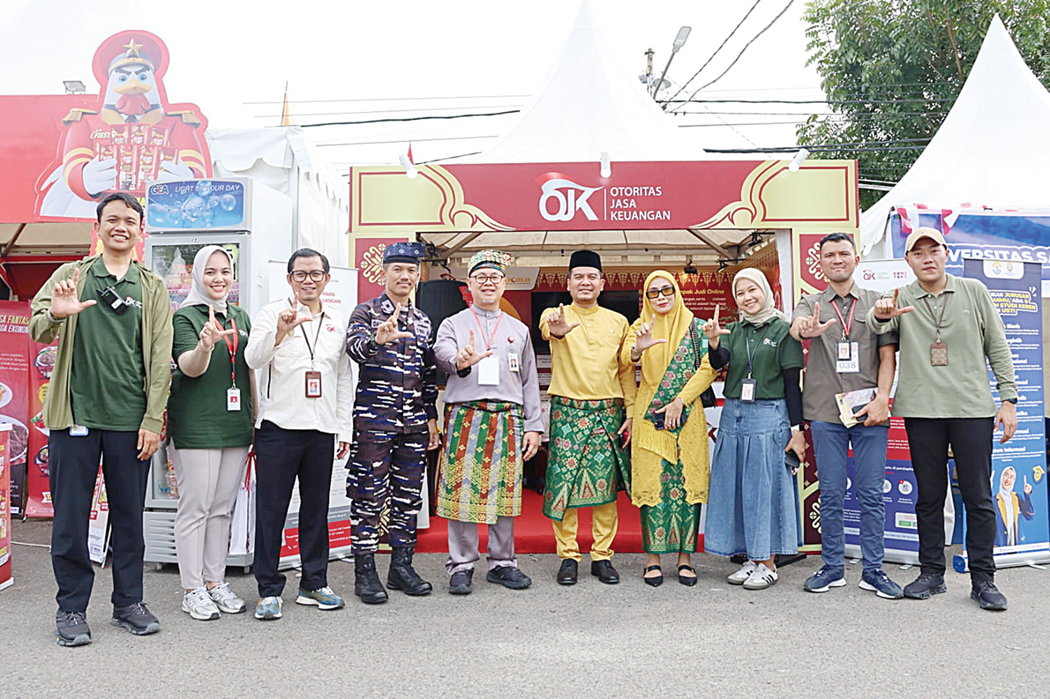 Kepala Otoritas Jasa Keuangan (OJK) Provinsi Riau  Triyoga Laksito (tengah, baju abu-abu) bersama Wakil Ketua Komite IV DPD RI Arif Eka Saputra (tengah, baju kuning) dan jajaran berfoto bersama di booth OJK Riau pada Pacu Jalur Expo 2025 di Kabupaten Kuan