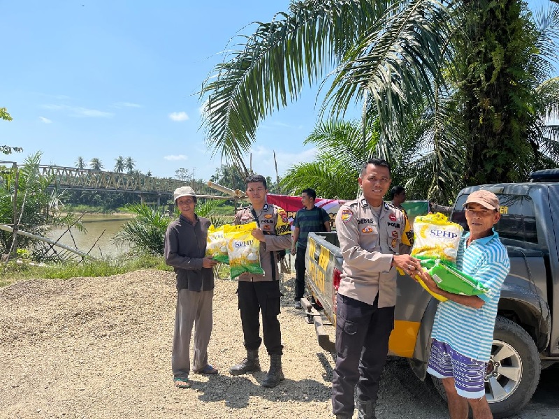 Personel Polsek Pasir Penyu saat melakukan pasar murah khusus beras untuk warga daerah aliran Sungai Indragiri, Selasa (26/8/2025)