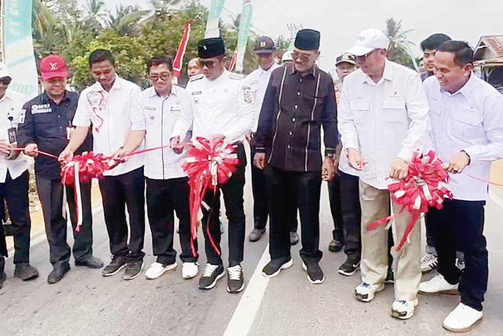 Bupati Pelalawan H Zukri SM MM (empat kanan) dan General Manager PT EMP Energi Riau Agung Budi Darmoyo (dua kanan) menggunting pita diresmikannya pemakaian jalan aspal sepanjang 3,4 Km.