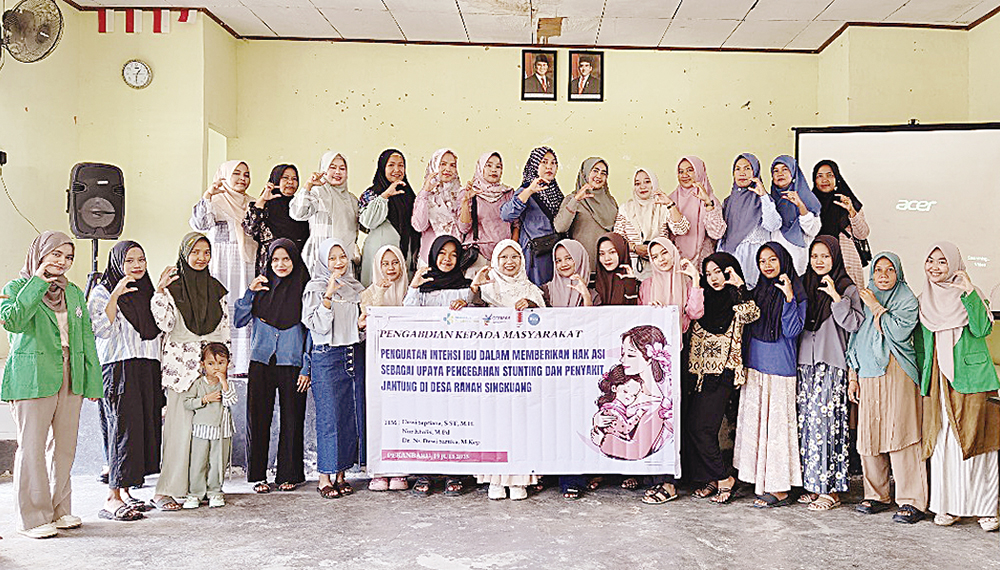 Ketua Tim Dosen Pengabdian Masyarakat Poltekkes Kemenkes Riau Dewi Septiana MH (tengah) foto bersama para ibu hamil dan menyusui di aula Kantor Lurah Desa Ranah Singkuang, Kebupaten Kampar, Sabtu (19/