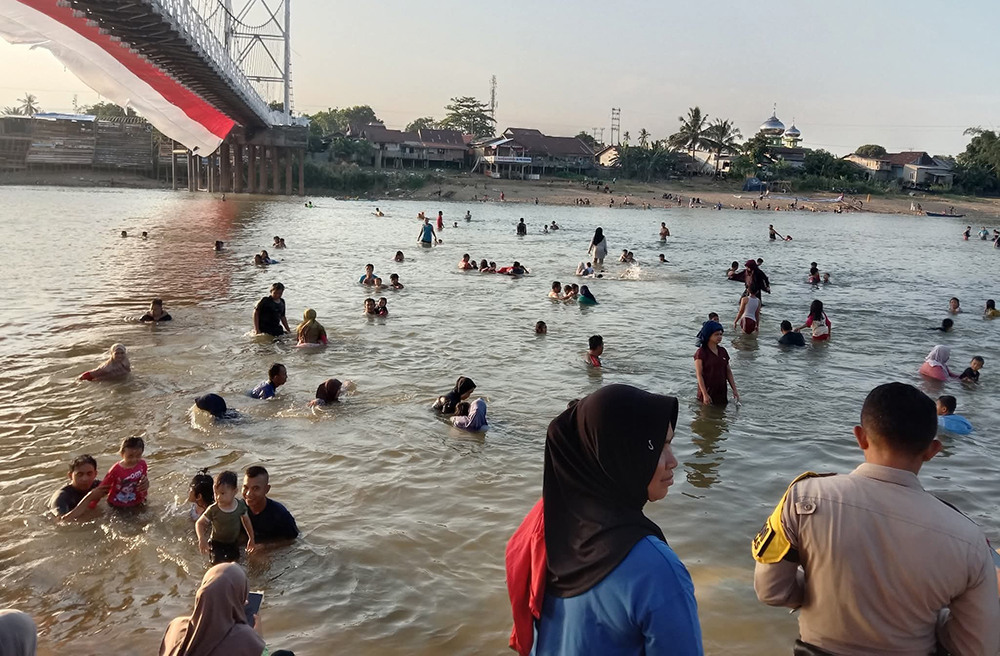 Masyarakat Kuansing ramai-ramai mandi di Sungai Kuantan, Rabu (27/8/2025) sore menyambut air sungai yang sudah jernih.